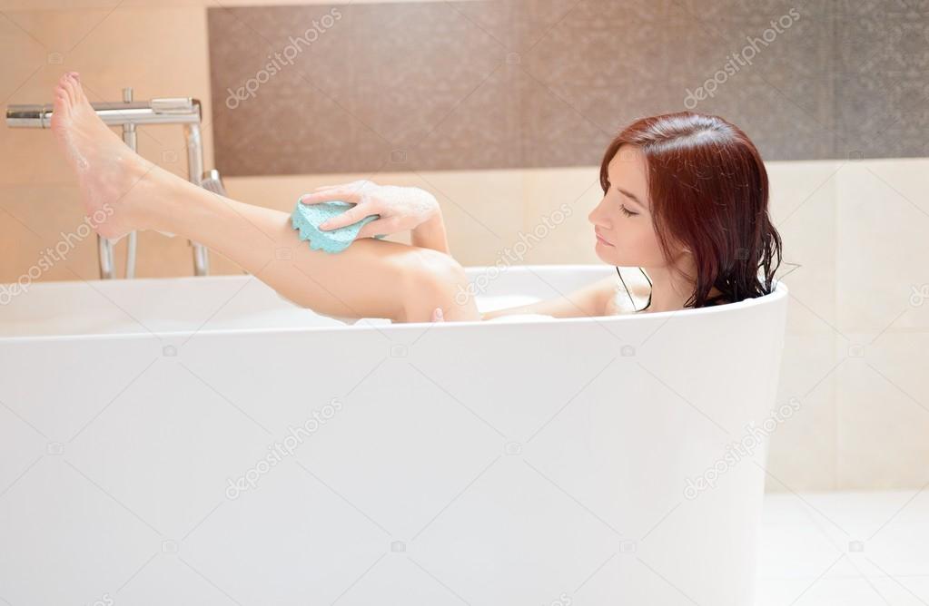 Young brunette woman taking bath