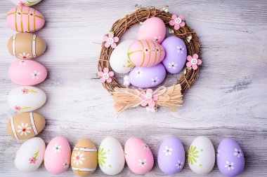 Yuvaya eski kırık ahşap arka plan üzerinde renkli Paskalya yumurtaları