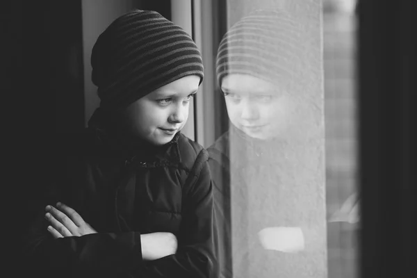 Βέβαιοι 7 χρονών αγόρι που κοιτάζει έξω από το παράθυρο - B&W — Φωτογραφία Αρχείου