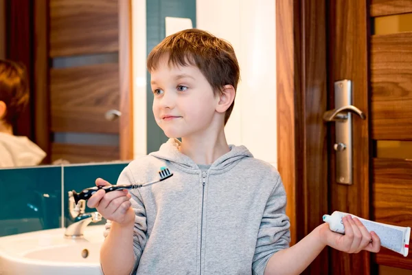 Kind borstelen zijn tanden in de badkamer. — Stockfoto