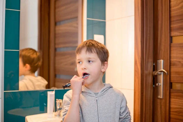 7 jaar oude jongen zijn tandenpoetsen in de badkamer — Stockfoto