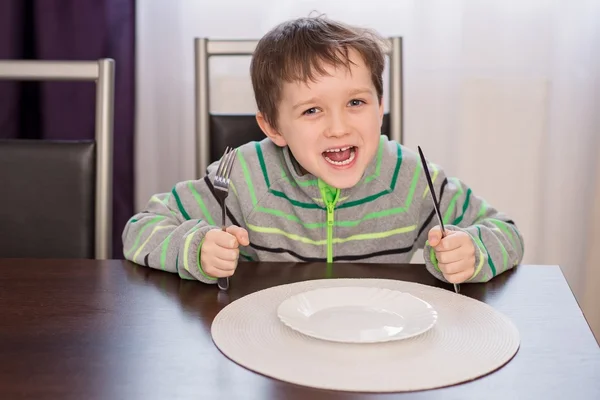 幸せな笑みを浮かべて少年子供夕食を待って. — ストック写真