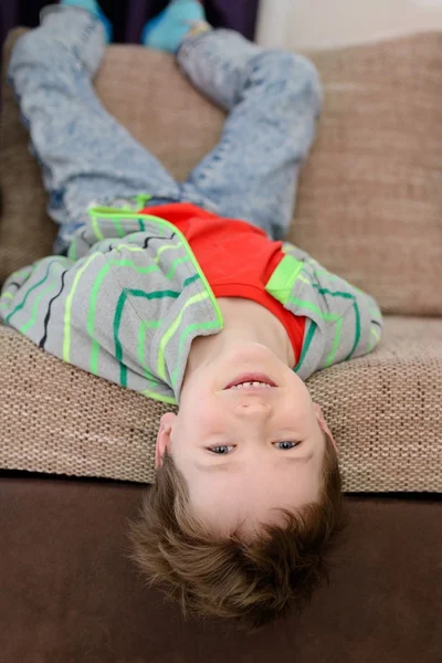 Sorrindo menino brincando no sofá — Fotografia de Stock