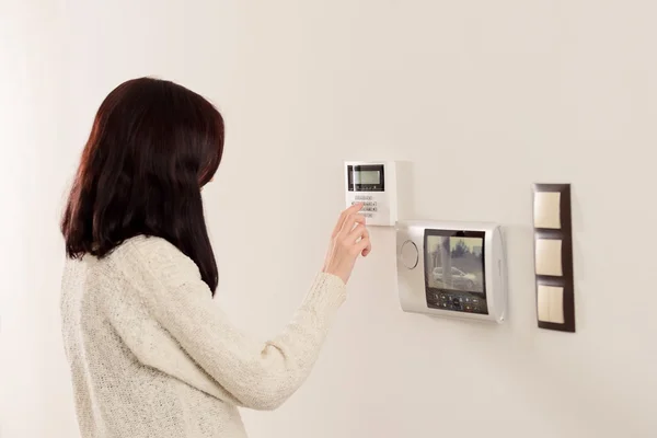 Woman entering code on keypad of home security alarm — Stock Photo, Image