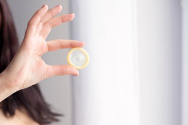 Kadın prezervatif güvenli seks için tutuyor.