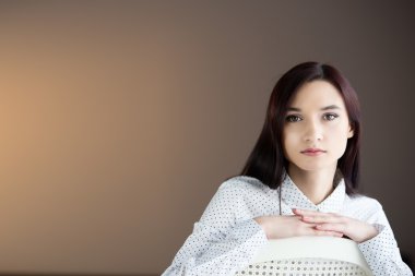 Güzellik esmer kadın sandalyede oturuyor.