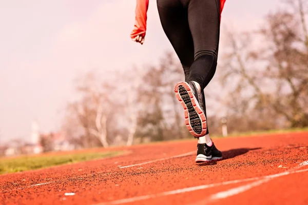 Donna che corre in pista in una soleggiata giornata primaverile . — Foto Stock