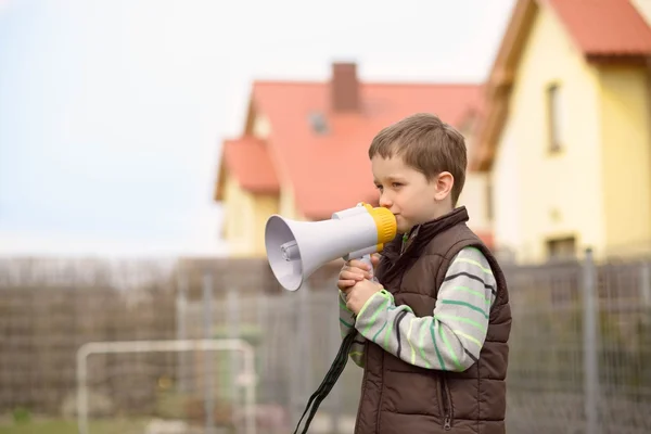 Jongen schreeuwt iets in de megafoon — Stockfoto