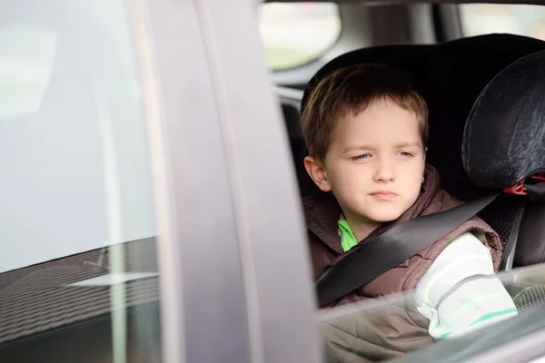 Беспокойный маленький мальчик в автомобильном кресле . — стоковое фото