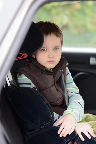 Szomorú kis fiú óvodás a biztonsági autósülés — Stock Fotó
