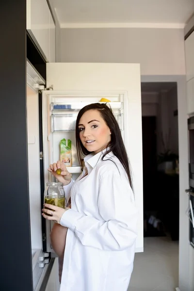 Donna incinta spuntino cetriolo sottaceto in cucina — Foto Stock