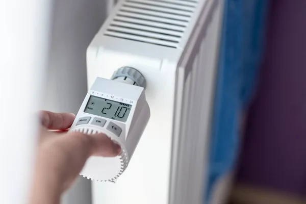 Mão da mulher ajustando a temperatura — Fotografia de Stock