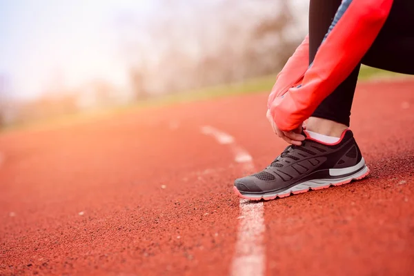Vrouw runner koppelverkoop haar schoen — Stockfoto