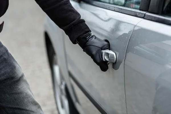 Ladrón de coches mano tirando de la manija de un coche —  Fotos de Stock