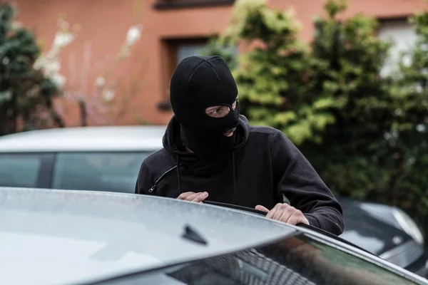 Ladrão de carros entrando no veículo e roubando um carro . — Fotografia de Stock