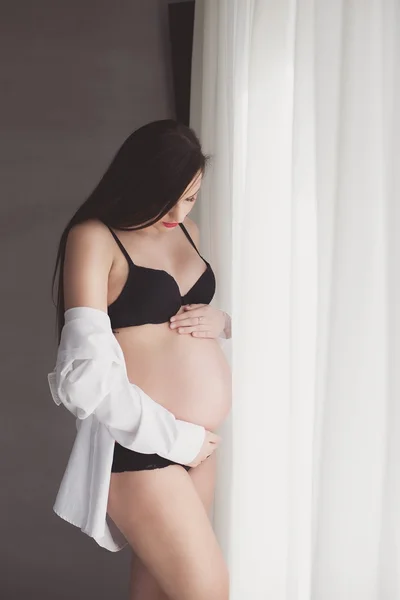 Bella donna incinta in camicia bianca e lingerie — Foto Stock