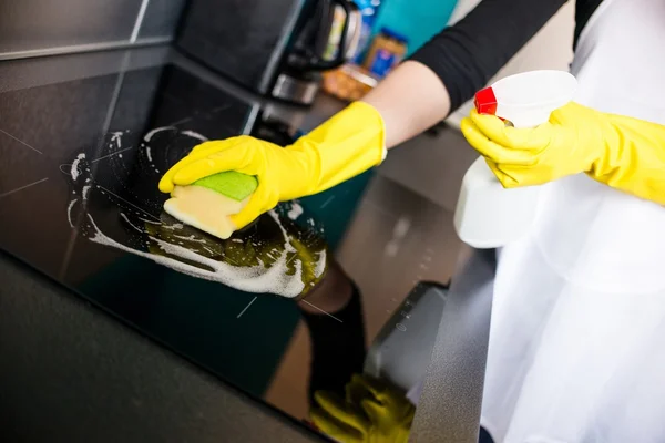 Жіночі руки очищення індукційної плити — стокове фото