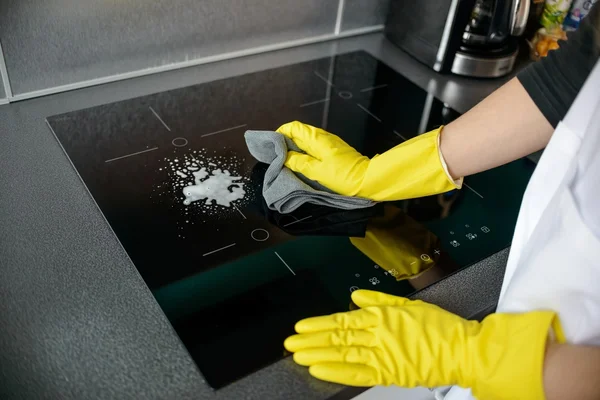 Woman's hands cleaning induction cooker — Stock Photo, Image