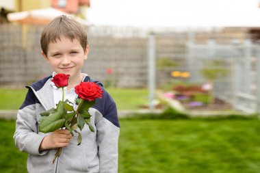 Bir buket gül tutan küçük çocuk