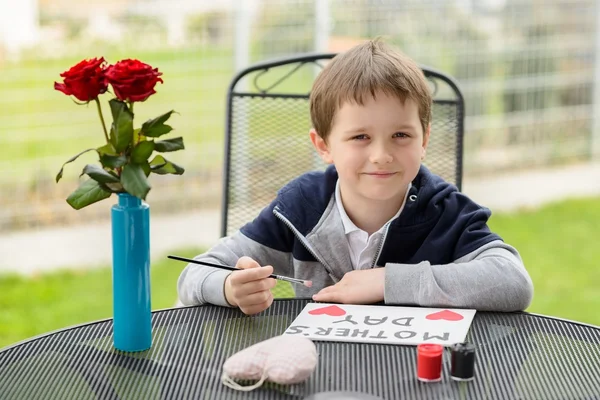 Kleiner Junge bemalt Grußkarte für seine Mutter — Stockfoto