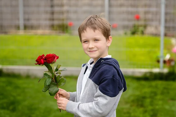 Ragazzino con in mano un mazzo di rose — Foto Stock