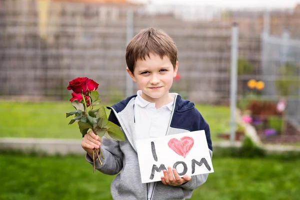 Chłopiec dając jego matka self-made powitanie karta — Zdjęcie stockowe