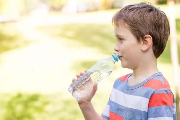 男孩从塑料瓶饮用矿泉水 — 图库照片