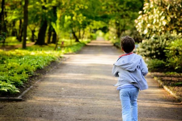 Pieni poika juoksemassa puistossa. Taustakuva — kuvapankkivalokuva