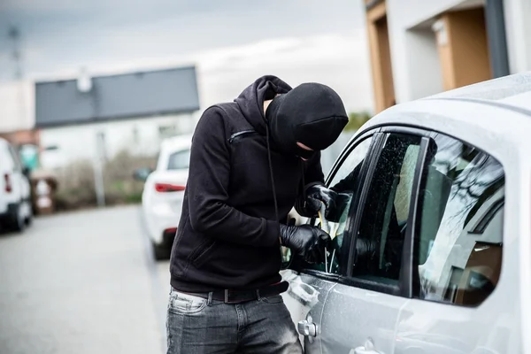 Ladrón de coches tratando de entrar en un coche con un destornillador —  Fotos de Stock