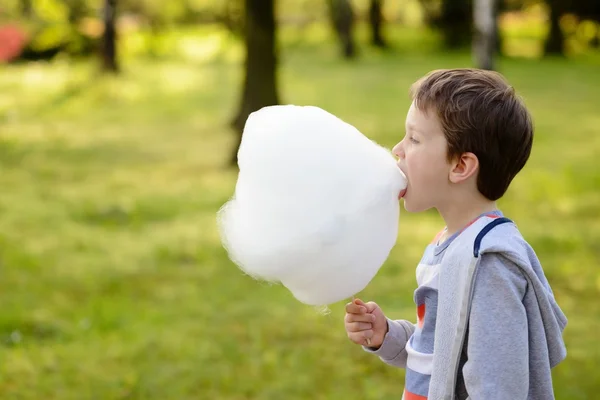 7 years boy eating candy floss in the park — Stock Photo, Image