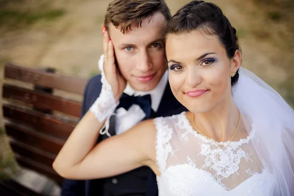 Recém-casados sentados no banco no parque — Fotografia de Stock