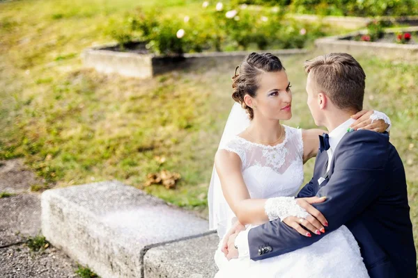 Belle mariée assise sur les jambes des mariés — Photo