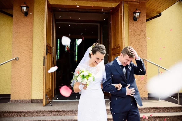 Newlyweds coming out of the church after wedding ceremony. — Stock Photo, Image
