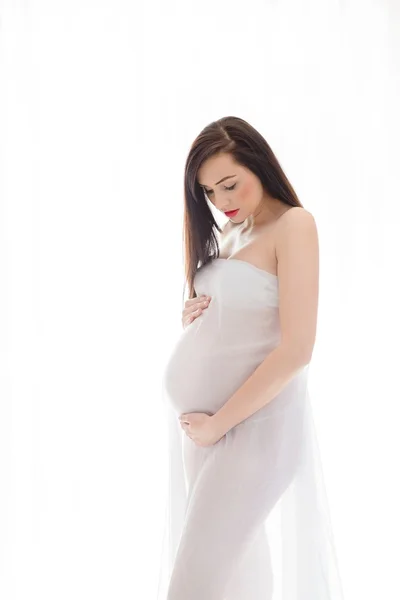 Brunette pregnant woman standing over white background — Stock Photo, Image