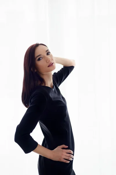 Mooie jonge brunette vrouw in zwarte jurk — Stockfoto