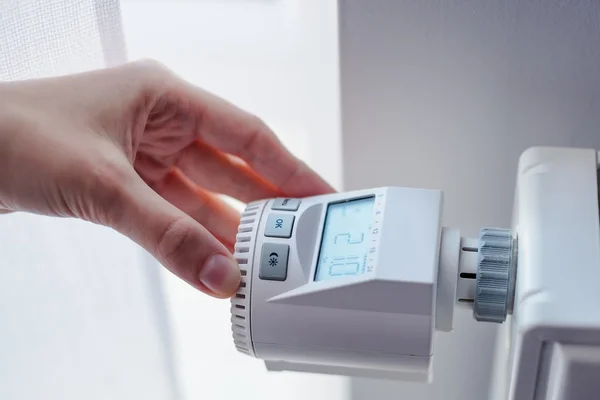 Mujer ajustando la temperatura del calentador del hogar — Foto de Stock