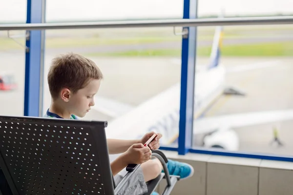 Znudzony 7 roku życia chłopiec dziecko czeka na jego samolot — Zdjęcie stockowe