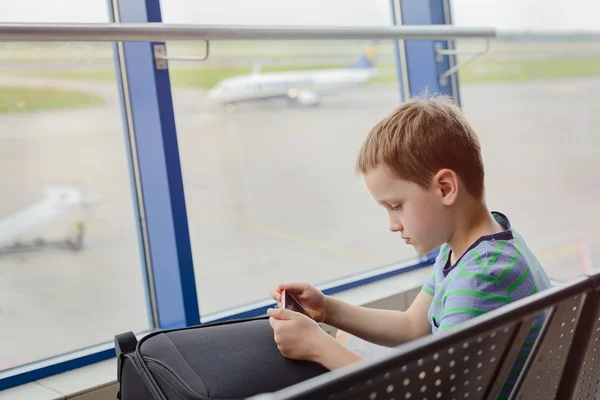 7-jähriger Junge wartet gelangweilt auf sein Flugzeug — Stockfoto