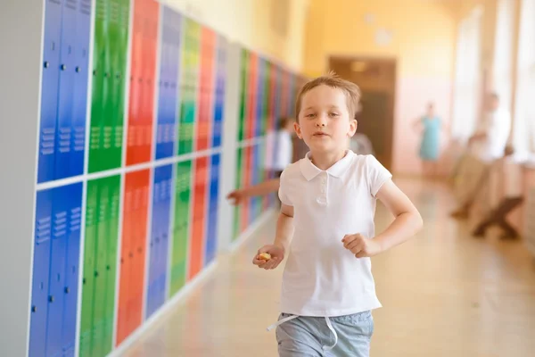 Glücklicher 7-jähriger Schüler läuft aus der Schule. — Stockfoto