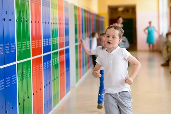 Glücklicher 7-jähriger Schüler läuft aus der Schule. — Stockfoto