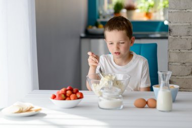 Çocuk beyaz peynir bir kase karıştırma