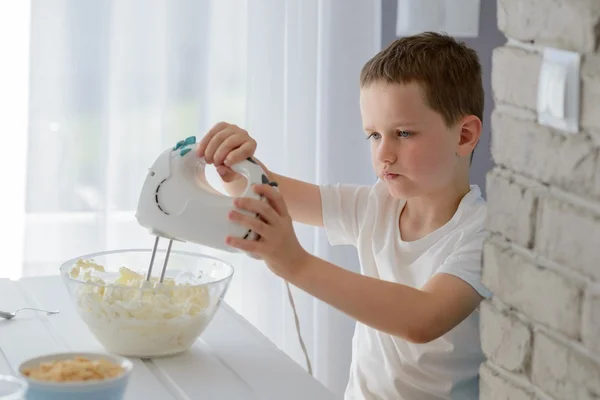 Kind mixt mit elektrischem Mixer weißen Quark — Stockfoto