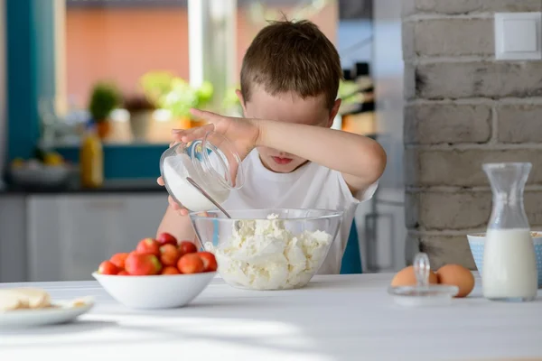 Niño añadiendo azúcar al requesón en un tazón . — Foto de Stock