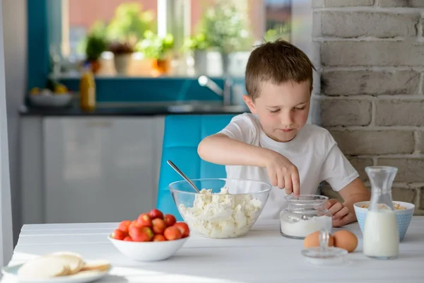 Niño añadiendo azúcar al requesón en un tazón . — Foto de Stock