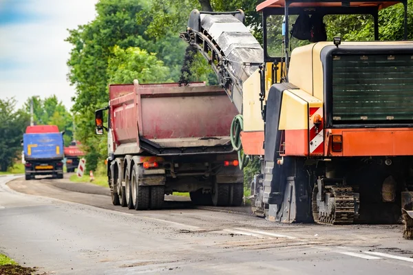 Asfalto removendo a máquina de carga de asfalto em pó no caminhão — Fotografia de Stock