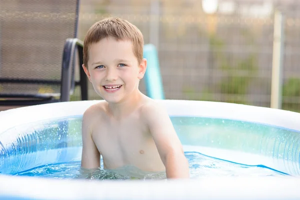 Szczęśliwy mały chłopiec w basenie w ogrodzie — Zdjęcie stockowe