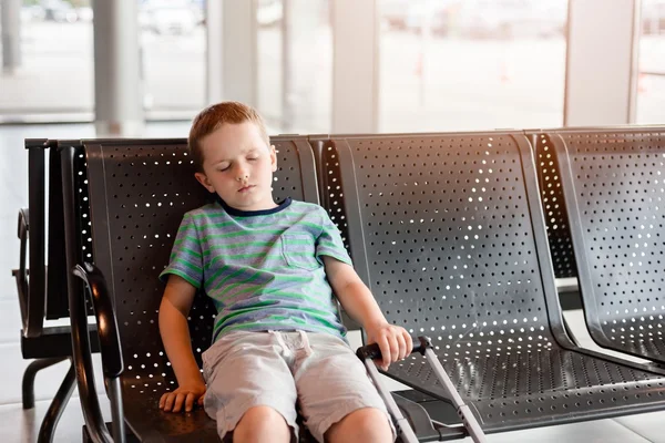 Niño cansado durmiendo en la sala de espera para pasajeros . —  Fotos de Stock