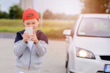 smartphone cep telefonu ile sokakta mobil oyunlar oynayan çocuk