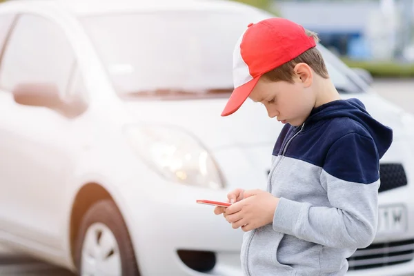 Enfant jouant à des jeux mobiles sur smartphone dans la rue — Photo