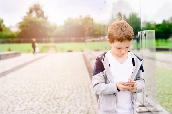 Mały chłopiec dziecko grając gier mobilnych na smartphone — Zdjęcie stockowe